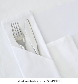 Table setting with blank menu card with white linen