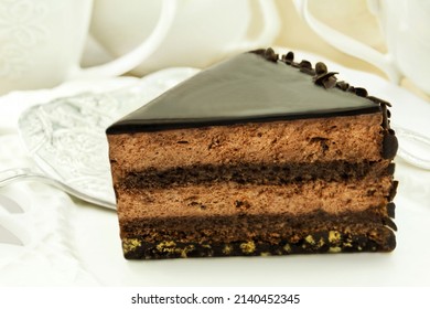 Table setting with Chocolate Cream Cake and coffee cups closeup