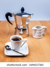 Table setting for coffee. Geyser coffee maker, milk jug and cup and saucer