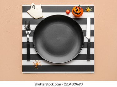 Table Setting With Cute Halloween Decor On Beige Background