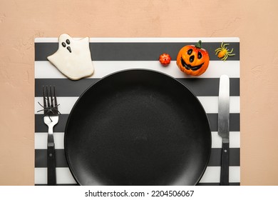 Table Setting With Cute Halloween Decor On Beige Background