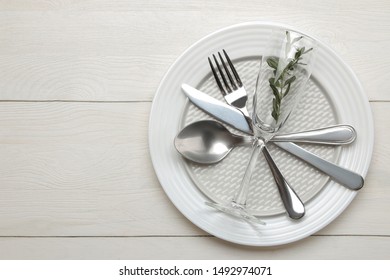 table setting. cutlery. Fork, knife, glass, spoon and plate on a white wooden table. top view - Powered by Shutterstock