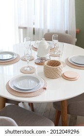 Table Setting With Dishes And Tableware In Stylish Modern Interior. No People. Dining  Table With Place Settings. Plates On Knitted Napkins, Glasses And Crochet Basket For Nuts Or Fruits.