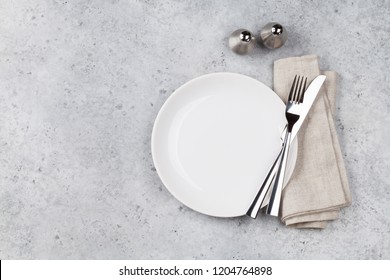 Table setting. Empty plate, knife, fork, spices and napkin. Top view and flat lay with copy space - Shutterstock ID 1204764898