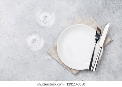 Table setting. Empty plate, knife, fork, wine glasses and napkin. Top view and flat lay with copy space - Shutterstock ID 1231148350