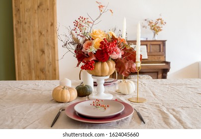 Table setting with empty plates and tableware. Seasonal table setting for two person. Red, orange, pink roses in pumpkin as decor, candles and squash on table - Powered by Shutterstock