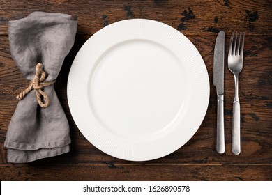 Table Setting With Empty White Plate, Cutlery And Table Napkin. Top View, Copy Space For Text. Dinner Table