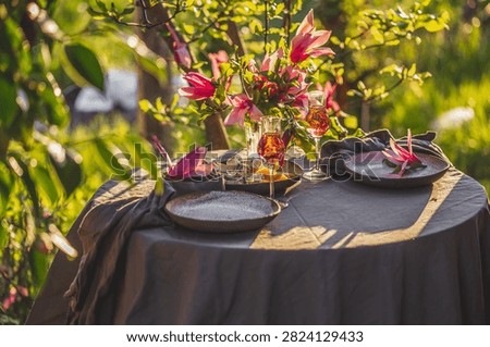 Table setting in garden on sunset light. Table decorated with magnolia flowers under magnolia tree