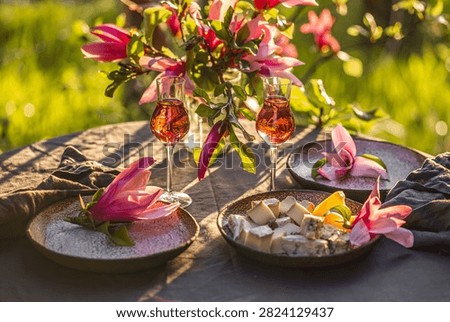 Table setting in garden on sunset light. Table decorated with magnolia flowers under magnolia tree