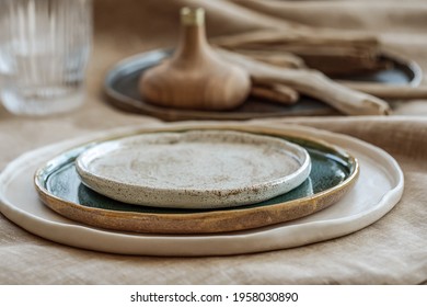 Table Setting With Handmade Craft Plates On Linen Tablecloth And Wood Accessories In Earth Tones