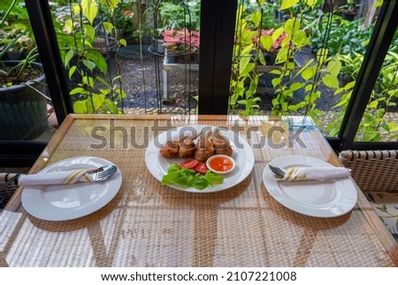 table setting for lunch with plate of fried chicken wings in the middle for appetizer