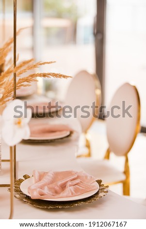 Table setting at a luxury wedding and Beautiful flowers on the table. wedding decor, flowers, pink and gold decor, candles. Festive table decor.