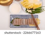 Table setting with makgeolli and skate ray sashimi