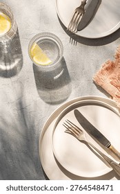 Table setting  minimally, elegant and  romantic. Two plates, two glasses of watter, linen napkins.
