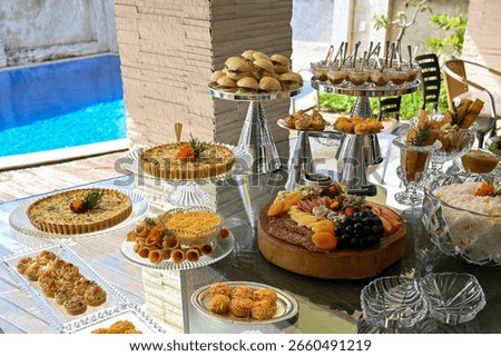 table setting,   table setting for a party, elegant buffet by the pool, outdoor event catering display, poolside party food table