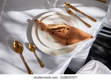 Table setting with sparkling wineglasses, plate with brown napkin and cutlery on table, copy space. Place set at wedding reception. Table served for wedding banquet in restaurant - Shutterstock ID 2108547077