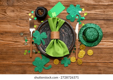 Table setting for St. Patrick's Day celebration with coins and hat on wooden background