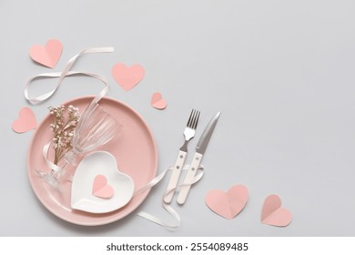 Table setting for Valentine's Day with ribbon, flowers and paper hearts on light background - Powered by Shutterstock