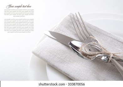 Table Setting In White And Gray Colors With Linen Napkins And Silverware 