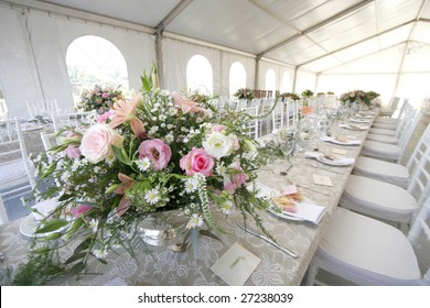 A Table Setup For A Wedding Reception In A Big Tent