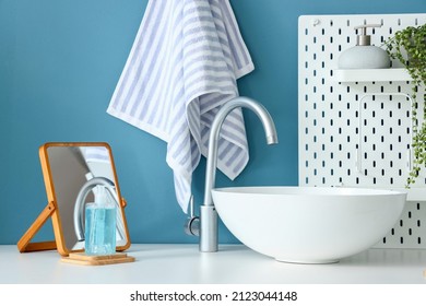 Table With Sink, Mirror, Soap And Pegboard Near Blue Wall