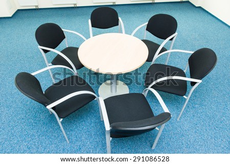 table and six chairs on the blue carpet