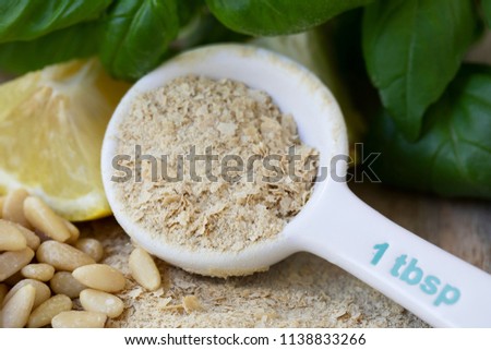 Table spoon of nutritional yeast for making vegan pesto.