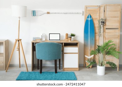 Table, surfboard, folding screen and paddle in interior of living room