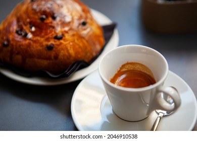 The Table With Sweets (pastries: Croissant, Cookies), White Cups (mug) With Hot Black Coffee (espresso), The Saucer, The Spoons At A Local Bar. Traditional Italian Breakfast. Milan, Lombardy, Italy