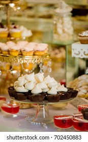 Table with sweets prepared for party. Candy bar. Delicious sweet buffet with cupcakes. Wedding Candy Bar.