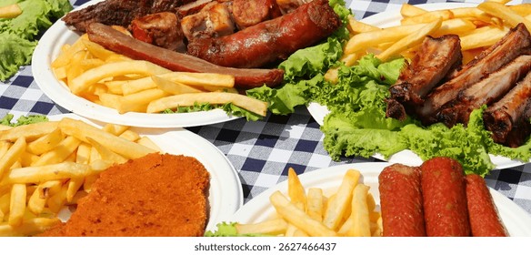 table with tablecloth and plates with chopped chips sausages in 