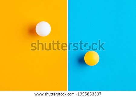 Table tennis balls in contrast. Competition, diversity, opposition or confrontation concept.