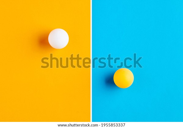 Table tennis balls in contrast.\
Competition, diversity, opposition or confrontation\
concept.