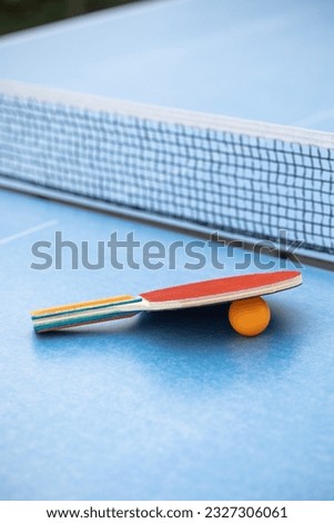 Table tennis. Blue ping pong table. Ping pong rackets and ball. The concept of sport and healthy lifestyle.
