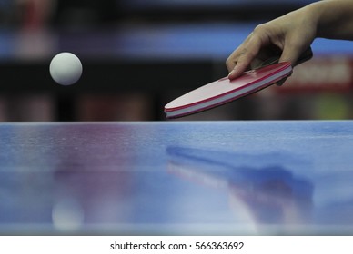 Table Tennis Ping Pong Paddles And White Ball On Blue Board.