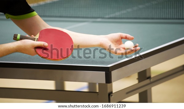 table tennis player\
doing a serve, close-up