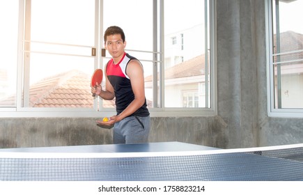 Table tennis player serving on table with net for table tennis. Playing table tennis indoor. Ping pong. - Powered by Shutterstock