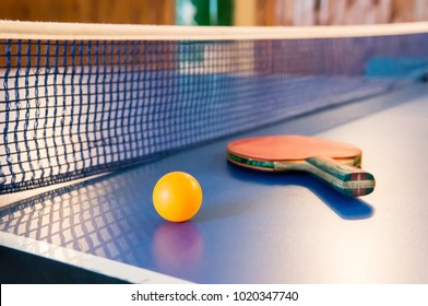 Table tennis - racket, ball, table. Tabletennis or ping pong rackets and yellow balls on blue table. Sport concept. Table tennis