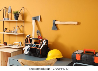 Table with tool box, hardhat and axe in carpenter's workshop