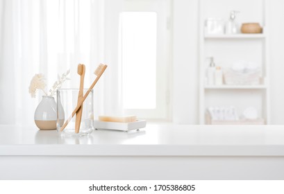 Table with toothbrushes and soap inside a bright defocused bathroom - Powered by Shutterstock