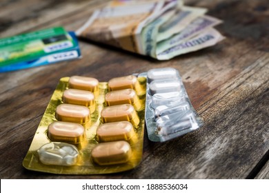 A Table Top Shot Of Medicines With Money And Credit Cards. A Large Amount Of People's Income Goes To Their Medical Bills