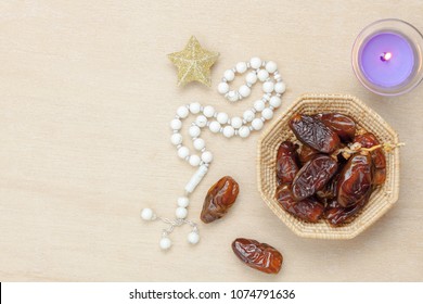 Table Top View Aerial Image Of Decoration Ramadan Kareem Holiday Background.Flat Lay Date In Wood Basket With White Rosary & Aromatherapy Candle .Essential Object Star On Rustic Wooden At Office Desk.