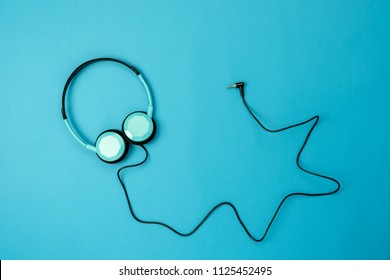 Table Top View Aerial Image Of Accessories Listening Radio Music Background Concept.Flat Lay Headphones On Modern Rustic Blue Paper Wallpaper.Free Space For Creative Design Text And Content.