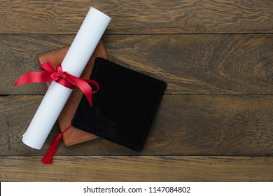 Table Top View Aerial Image Of Graduation Of Education Season Background Concept.Flat Lay Accessories Cap With Certificate Paper & Book  On Modern Rustic Brown Wooden.Free Space For Design Mock Up.