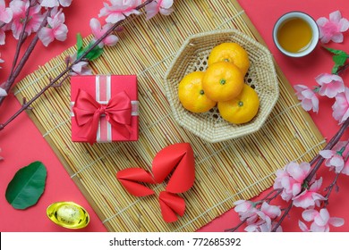 Table top view aerial image of Chinese & Lunar new year background concept.Beautiful gift box & orange with decoration festive.Mix object on the modern rustic red wallpaper at home office desk studio.