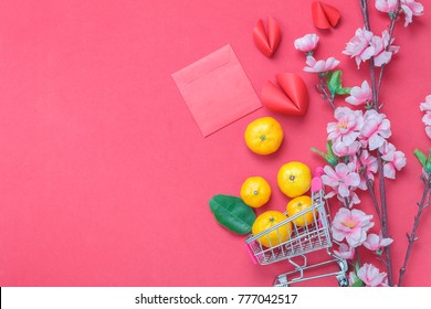 Table top view of arrangement decoration Chinese new year & lunar holiday background concept.Orange in shopping cart or trolley with accessories on modern red wood wallpaper.Idea shopping in season.