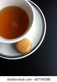 Table top view of macaron and tea on the black table.