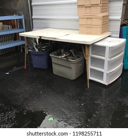 Table With Tubs, Hangers, Plastic Drawers Outside After A Rain At Thrift Store