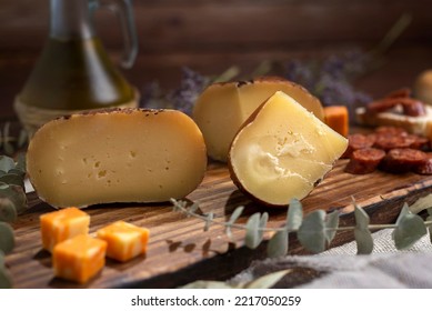 Table With Varieties Of Cheese Brie Camembert Cheddar Parmesan Cheese With Bell Peppers On A Wooden Board Adorned With Dried Flowers Oil And Pepper Shaker