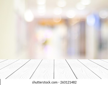 Table White Wood Perspective Background, Top Of Wooden Surface, Tabletop, And Blurred Store With Bokeh Light, Blank  Counter, Shelf At Shop For Product Display Mockup, Template, Business Background